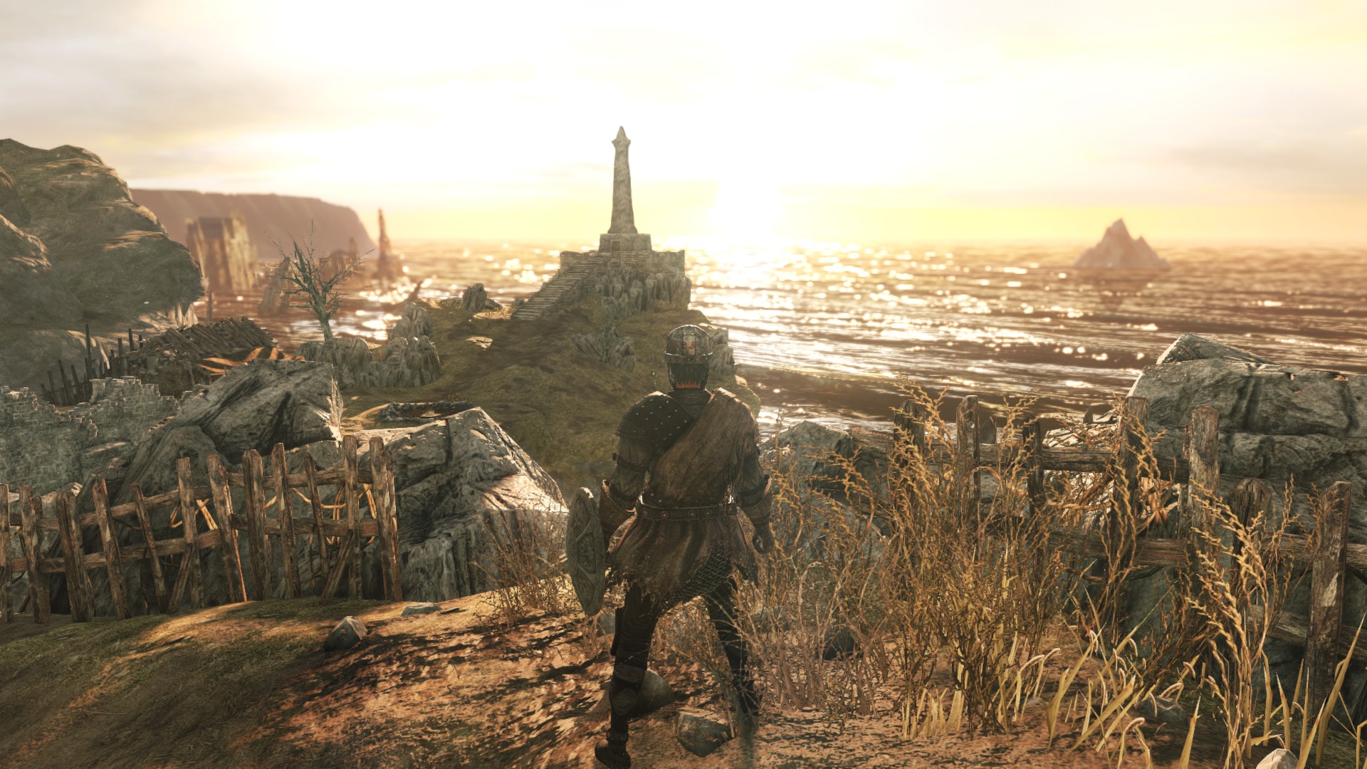 A warrior faces into the setting sun on a fenced cliff side. In the distance a tower on a promontory is silhouetted. Glistening waves roll in from the sea.
